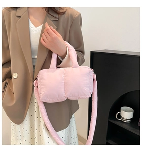 Détail du sac cabas rose matelassé avec bandoulière amovible porté par un mannequin