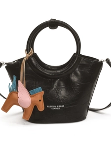 Black crocodile embossed tote bag with round handles and a colorful pegasus charm