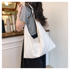 Detailed view of cream canvas hobo bag showing large capacity and soft drape