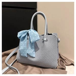Détail du sac seau bleu clair montrant la texture du tissu et le nœud à pois bleus