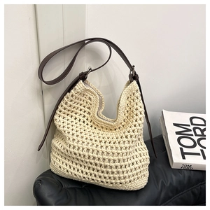 Détail du sac hobo en crochet beige avec bandoulière réglable en cuir marron foncé de luxe