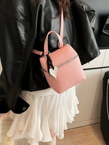 Mini borsa a scatola rosa con ciondolo a cuore indossata per un look alla moda