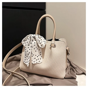 Détail du sac cabas en toile avec texture tissée, foulard à pois et bandoulière réglable