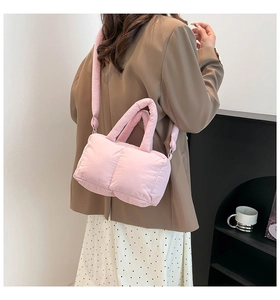 Sac à bandoulière rose matelassé porté avec un blazer marron et une jupe à pois