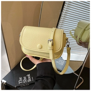 Detail of light yellow cross-body bag with lychee texture and mirror reflection view
