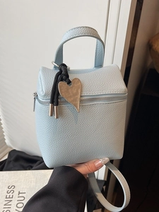 Borsa quadrata azzurra in pelle martellata con ciondolo a cuore e manico superiore