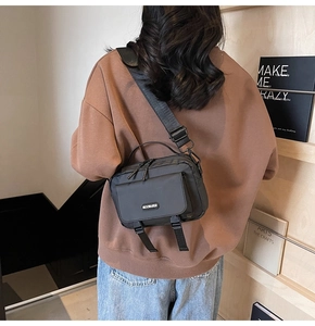 Detailed view of back-carried black nylon tactical crossbody bag with buckle straps