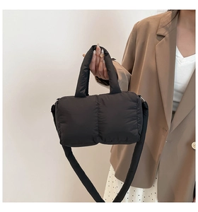Détail d'un grand sac matelassé noir avec poignées rembourrées et bandoulière large