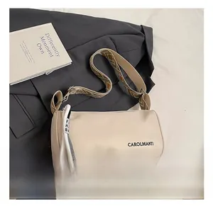 Détail du sac bandoulière crème avec logo et large sangle tissée à motifs géométriques
