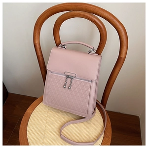 Detail view of pink leather bag with embossed geometric texture and metal ball zippers