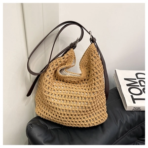 Détail du sac seau en paille crocheté beige avec bandoulière en cuir marron foncé