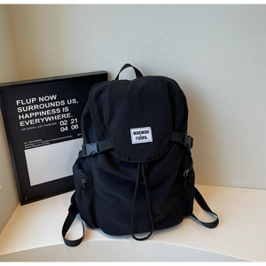 Detail of canvas backpack featuring drawstring closure and buckle straps for secure storage