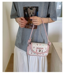 Detailed shot of pink ballet style crossbody bag featuring bow and cartoon pattern