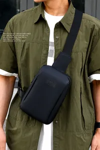 Detail der schwarzen Herren-Brusttasche mit matter Textur und SPORT-Logo auf grünem Hemd