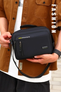 Detail der schwarzen Nylontasche mit Gummigriff und Multi-Pocket-Struktur