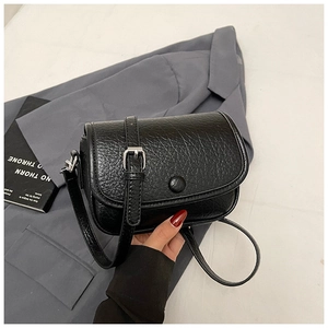 Close-up of black leather crossbody bag with textured finish and elegant strap detail