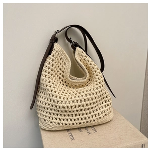 Détail du sac seau au crochet beige avec texture en maille et bandoulière en cuir marron