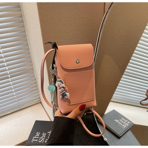 Détail de la pochette bandoulière rose avec pendentif chiot mignon et poche avant pratique