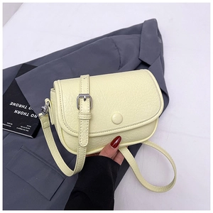 Detail of cream yellow pebble leather crossbody bag with adjustable silver buckle strap