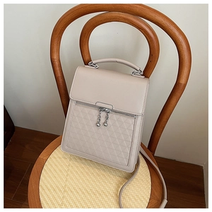 Detail of beige faux leather handbag with embossed triangle pattern and ball chain zipper