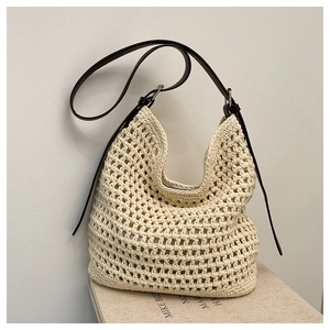Détail de la texture en coton tressé crème avec bandoulière en cuir marron du sac hobo