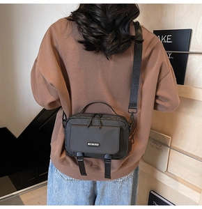Close-up of the black waterproof nylon messenger bag featuring the Moonlersa logo detail