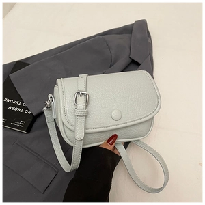 Detail of light blue pebble leather crossbody bag with silver hardware and adjustable strap