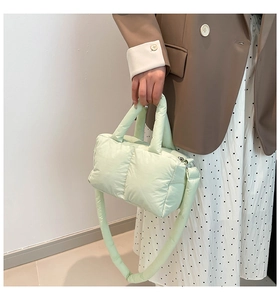 Détail du sac fourre-tout matelassé vert clair avec poignées souples et texture nylon