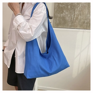 Macro detail of a bright blue canvas hobo bag showing large capacity and thick fabric texture