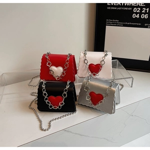 Detail of mini heart-shaped crossbody bags with wavy edges and decorative metal chains