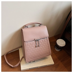 Detail of pink quilted handbag showing diamond pattern and metal ball zipper charm