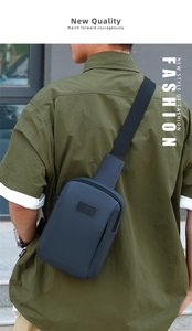 Detail of navy blue waterproof chest bag with wide strap on green shirt outdoor