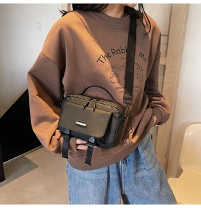Practical utility crossbody bag in black nylon with buckle straps shown on a model