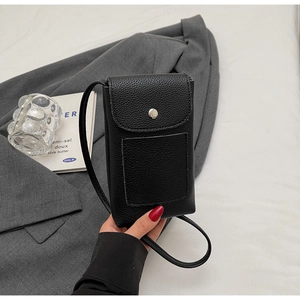 Gros plan du mini sac bandoulière noir texture litchi avec boucle argentée en main