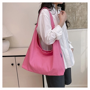 Side view of large pink canvas tote bag with wide shoulder strap for daily commuting