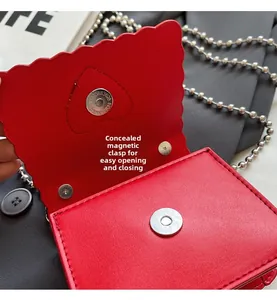 Close-up of a red mini heart bag showing wave edge, silver magnetic closure and ball chain