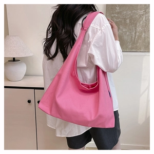 Detailed texture of pink canvas tote bag showing wide shoulder strap and woven fabric