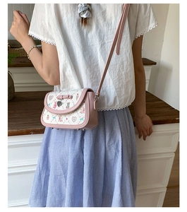 Detailed view of the pink ballet style crossbody bag featuring a 3D bow and cartoon print