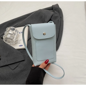 Détail d'un sac téléphone bleu clair en cuir grainé avec boucle et fente pour carte