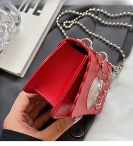 Macro shot of red heart shaped mini bag interior with wavy edges and silver chain
