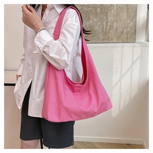 Detailed texture of bright pink canvas tote bag showing wide shoulder strap and fabric