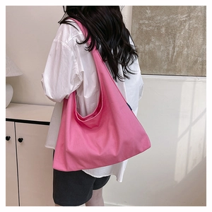Pink canvas large capacity hobo shoulder bag shown on a model for casual commuting