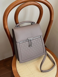 Minimalist taupe leather handbag with triangular quilting and silver chain zipper puller