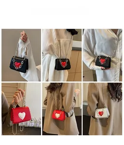 Detailed views of mini heart-shaped crossbody bags with scallop edges and bead chains