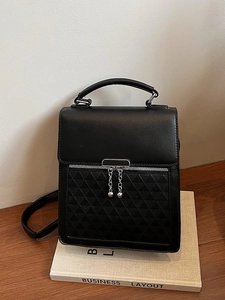 Black leather handbag with geometric triangle embossing and silver chain detail