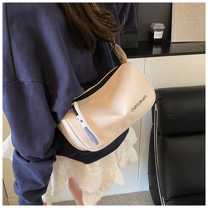 Détail d'un sac bandoulière beige avec large sangle tissée et logo CAROLMANTI