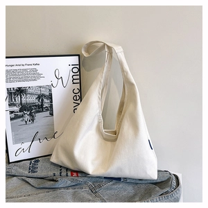 Detailed view of the soft drape and natural folds of a minimalist off-white canvas tote bag