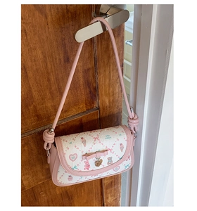 Detailed view of pink ballet-style crossbody bag with ice cream and bow pattern