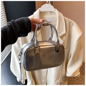 Detail of silver metallic bowling bag with smooth finish and adjustable shoulder strap