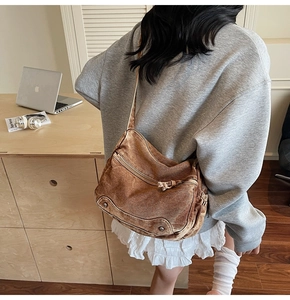 Detail of vintage brown canvas tote bag with metal buckle and washed fabric texture